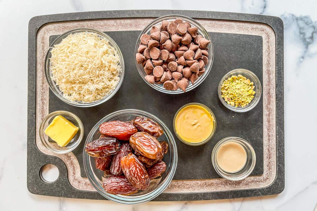 Ingredients for Dubai chocolate dates on a black cutting board.