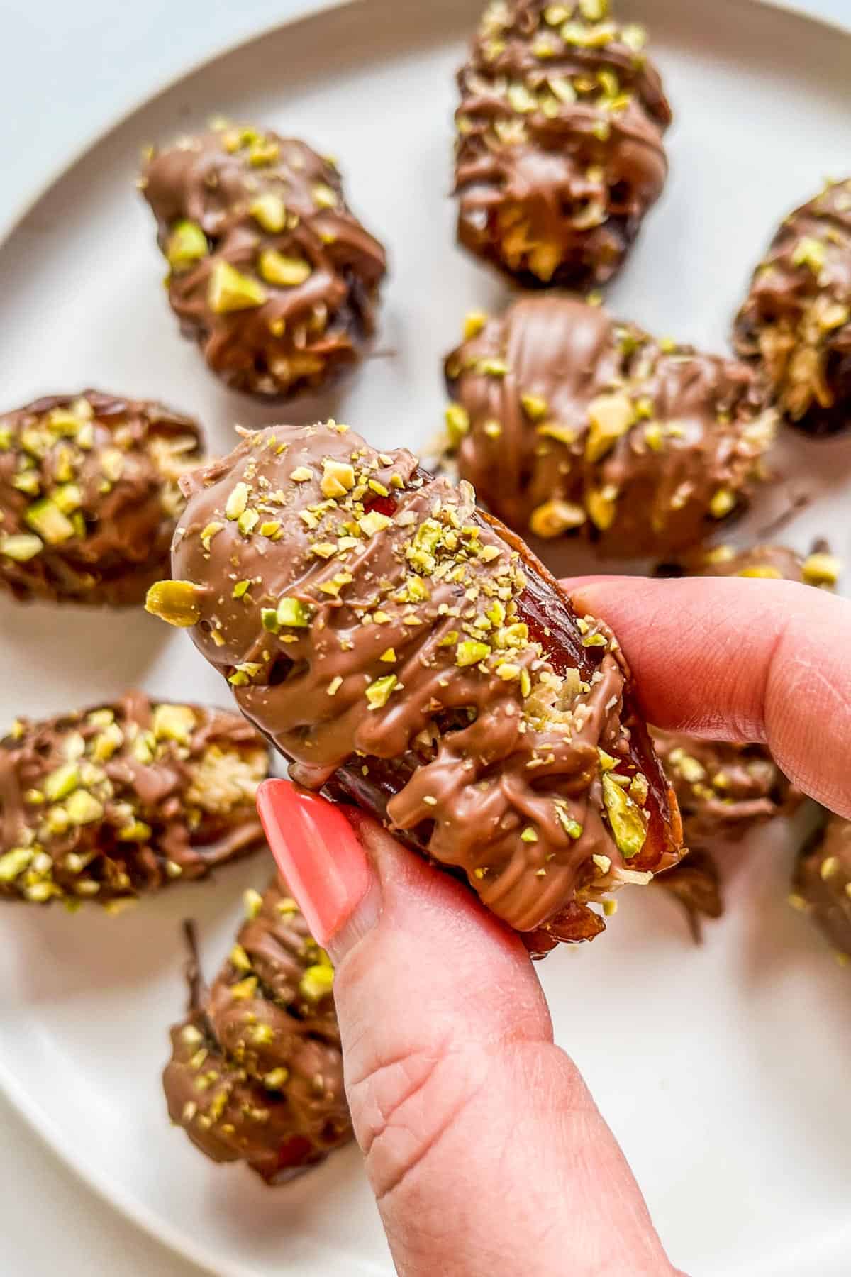 Dubai chocolate dates on a white plate.