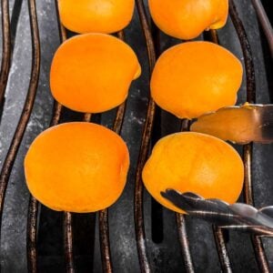 Apricot halves being added to the grill.