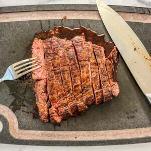Sliced flank steak on a cutting board.