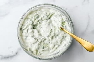 Yogurt cucumber sauce in a glass bowl.