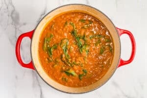Coconut lentil curry with spinach in a pot.
