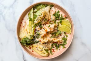 Coconut curry dumpling soup in a pink bowl.