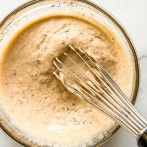 Whisking remoulade in a mixing bowl.