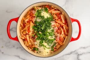 Pasta with tomatoes and pancetta topped with parmesan and herbs.