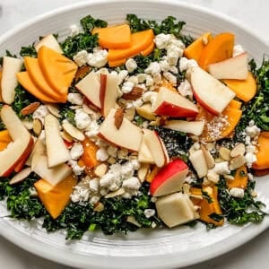 Pears, persimmon, goat cheese, and kale on a platter.