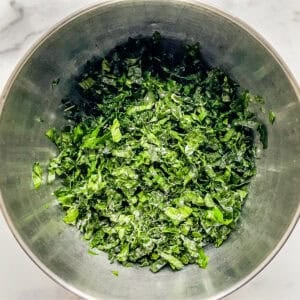 Massaged kale in a metal mixing bowl.