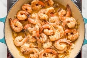 Shrimp being cooked in sauce.