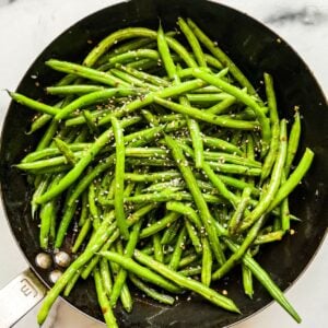 Asian green beans with sesame seeds in a skillet.