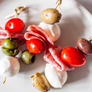 Antipasto skewers on a white plate.