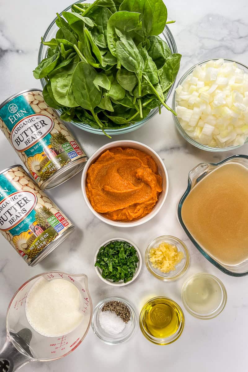 Ingredients for pumpkin butter beans on a marble background.
