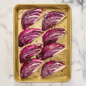 Cabbage wedges on a small gold sheet pan.