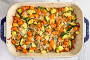 Baked sweet potatoes, zucchini, ground turkey, and cheese in a baking dish.