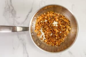Spices and onions being cooked in a pot.