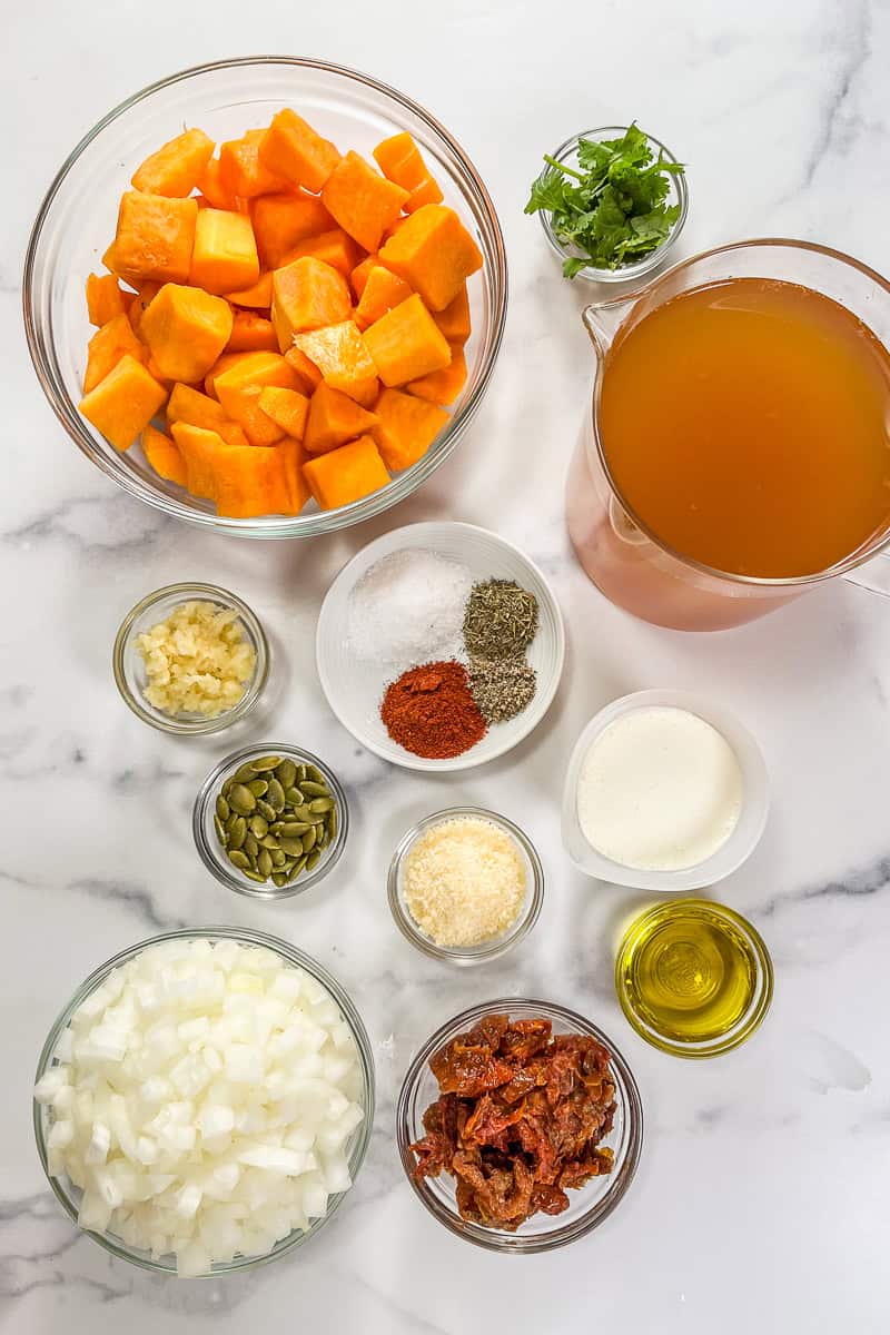 Ingredients for marry me butternut squash soup on a marble background.