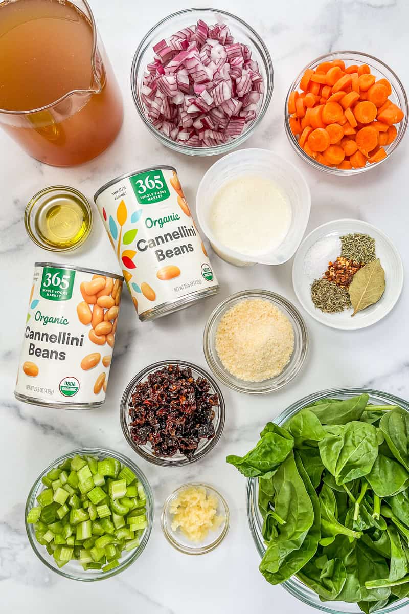 Ingredients for marry me white bean soup on a marble background.