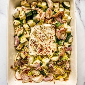 Baked feta with zucchini and leeks in a baking dish.