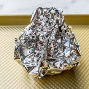 An onion wrapped in aluminum foil.