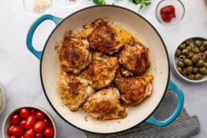 Chicken thighs being cooked in olive oil.