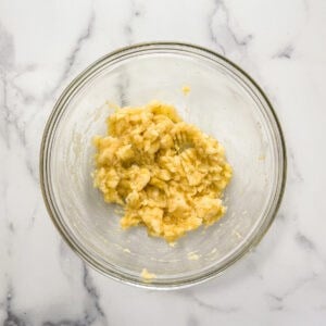 Mashed banana in a large glass bowl.