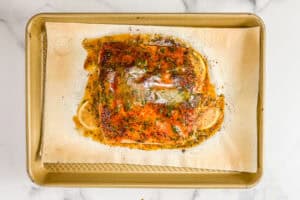 Dijon honey salmon with lemon on a gold sheet pan.