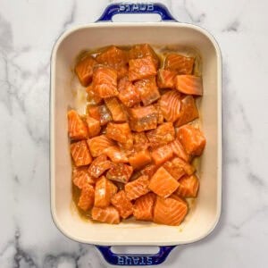 Chunks of raw salmon with a miso sauce in a baking dish.