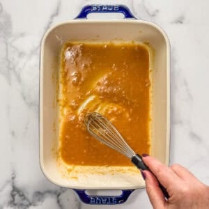 A miso sauce being whisked in a baking dish.