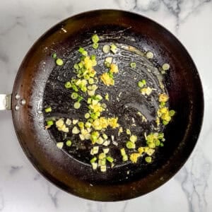 Chopped ginger, garlic, and green onions in a large pan.