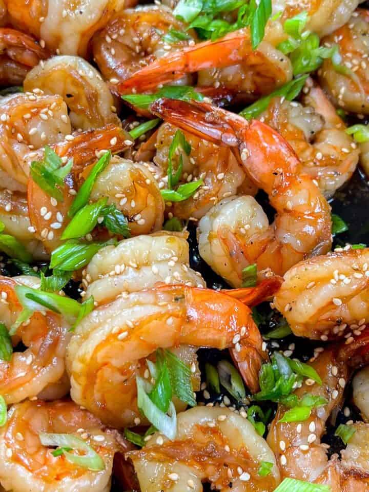 Honey soy garlic shrimp topped with sliced green onions and sesame seeds.