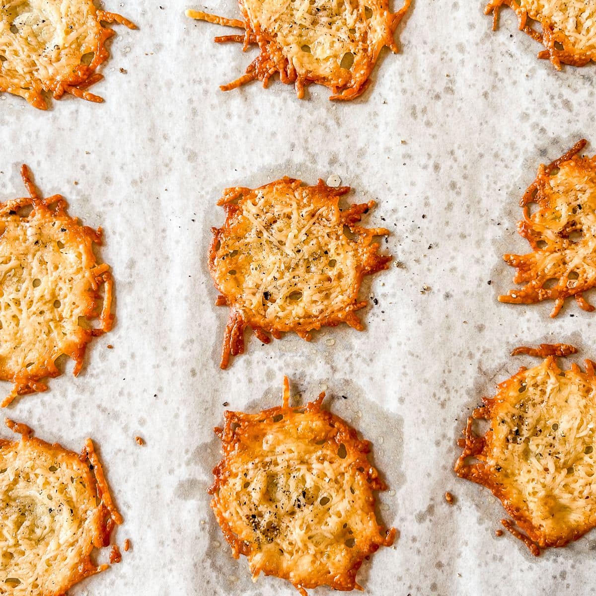 Parmesan cheese crisps on a piece of parchment.