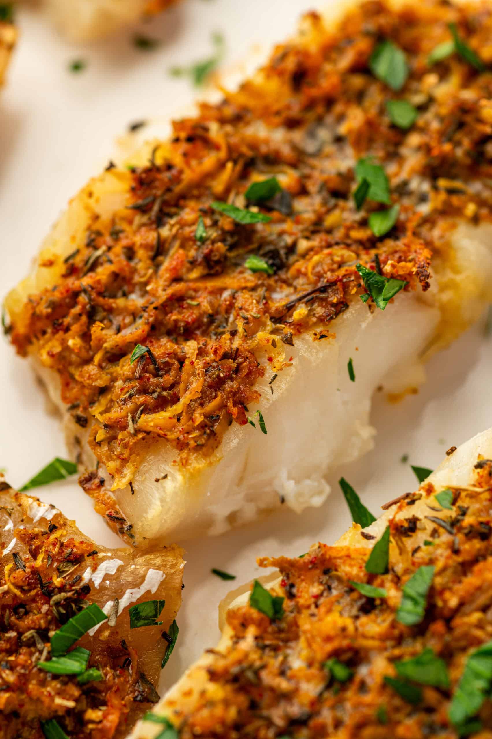 Citrus herb crusted cod on a white plate.