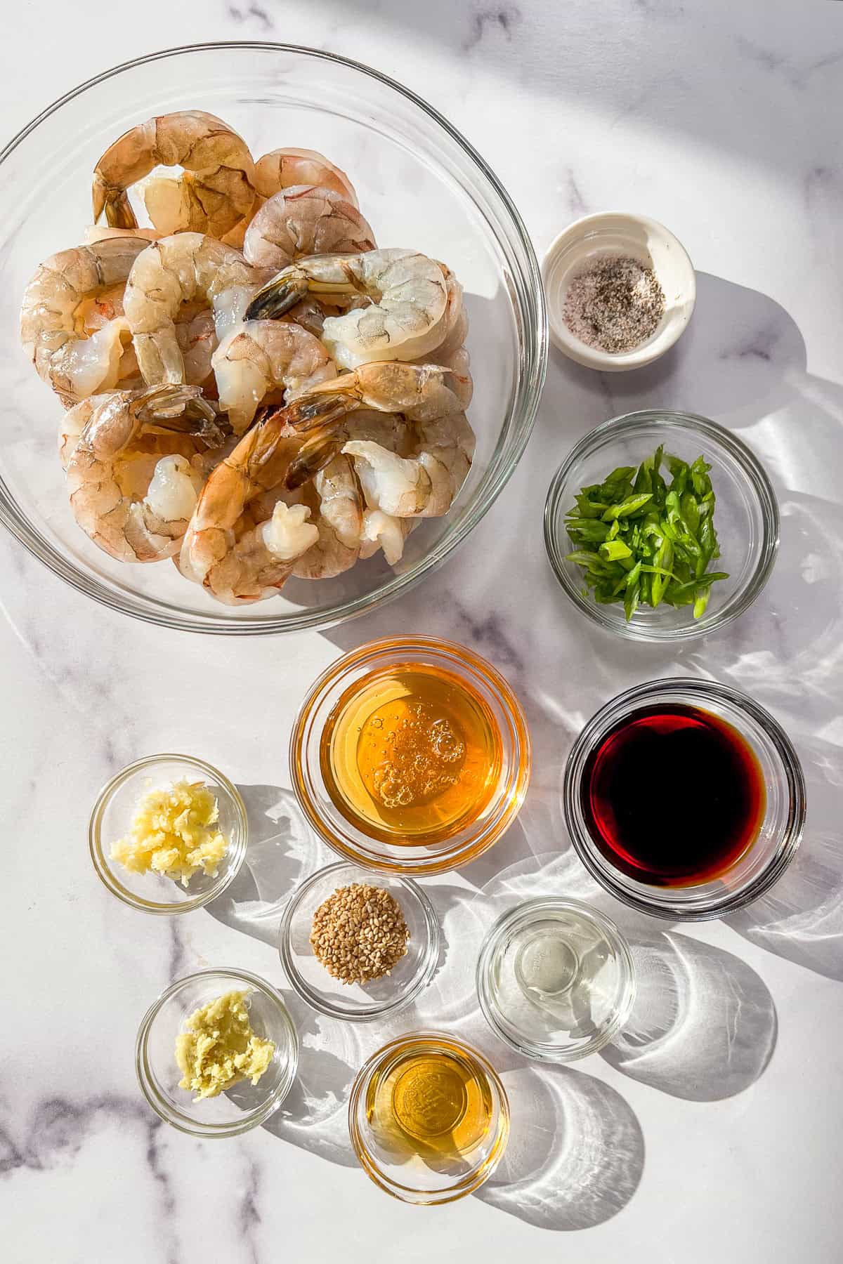Glass bowls with ingredients for honey garlic shrimp.