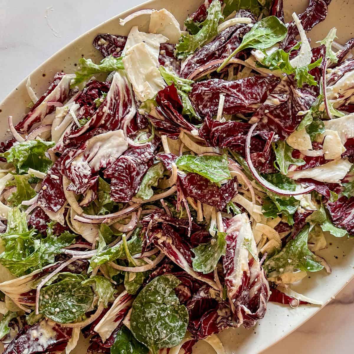 Dressed salad greens on a platter.