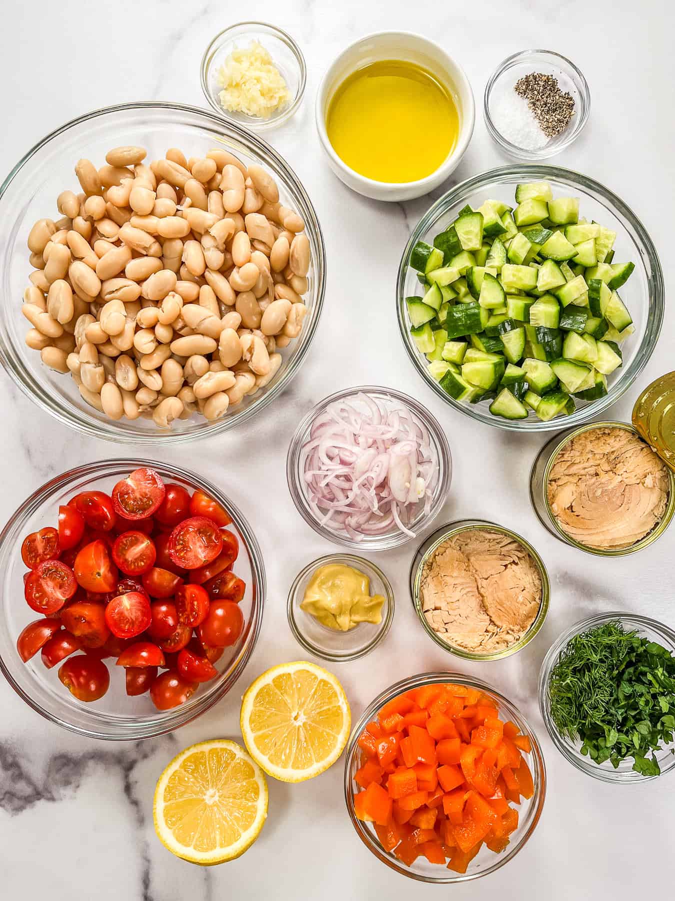 Ingredients for white bean tuna salad in glass bowls.
