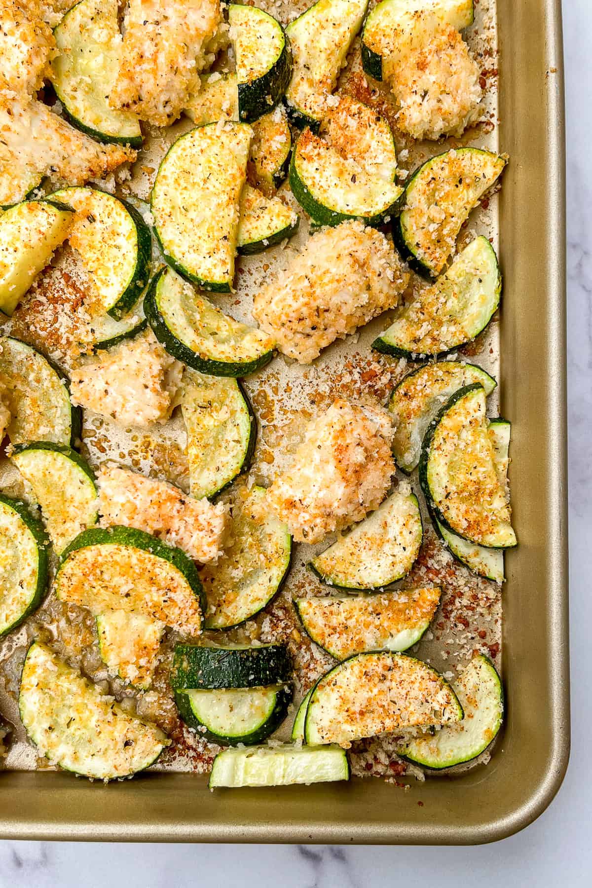 Crispy chicken and zucchini on a sheet pan.