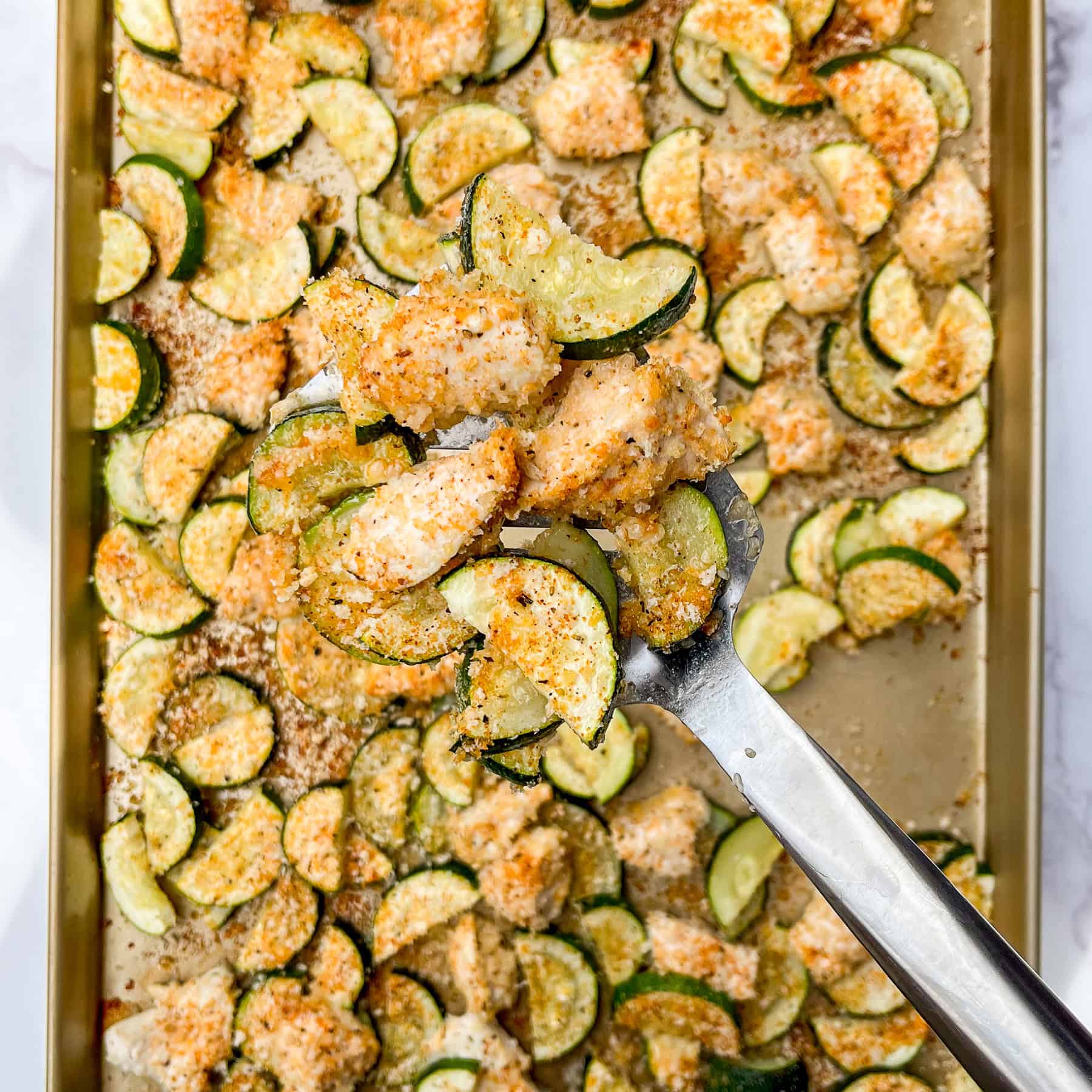 Crispy panko parmesan chicken and zucchini on a sheet pan.