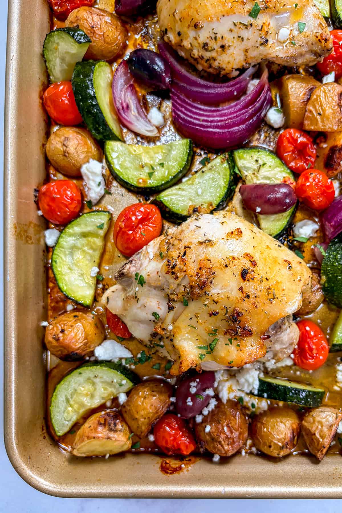 Sheet pan Greek chickens thighs with vegetables.