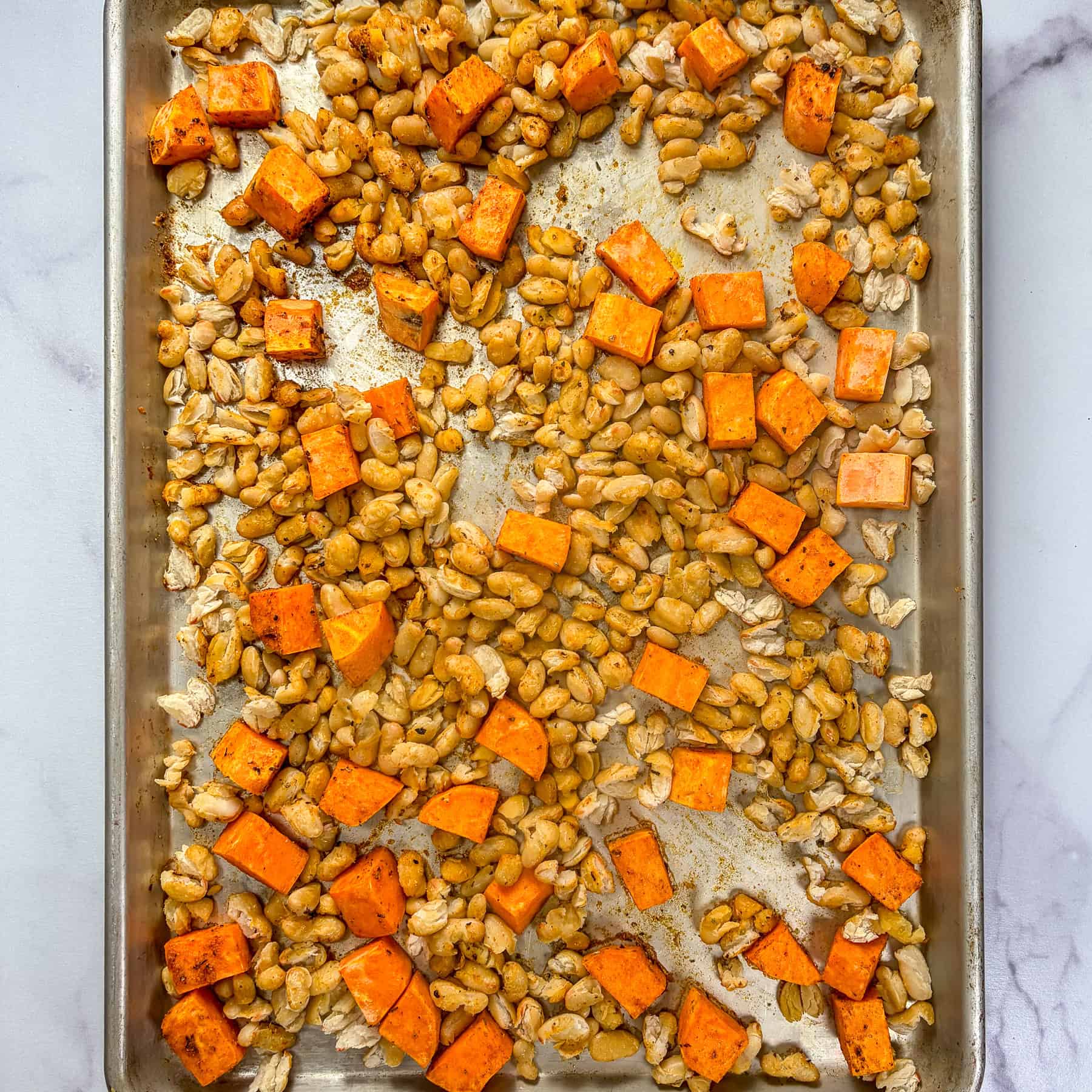 White beans and sweet potato on a sheet pan.