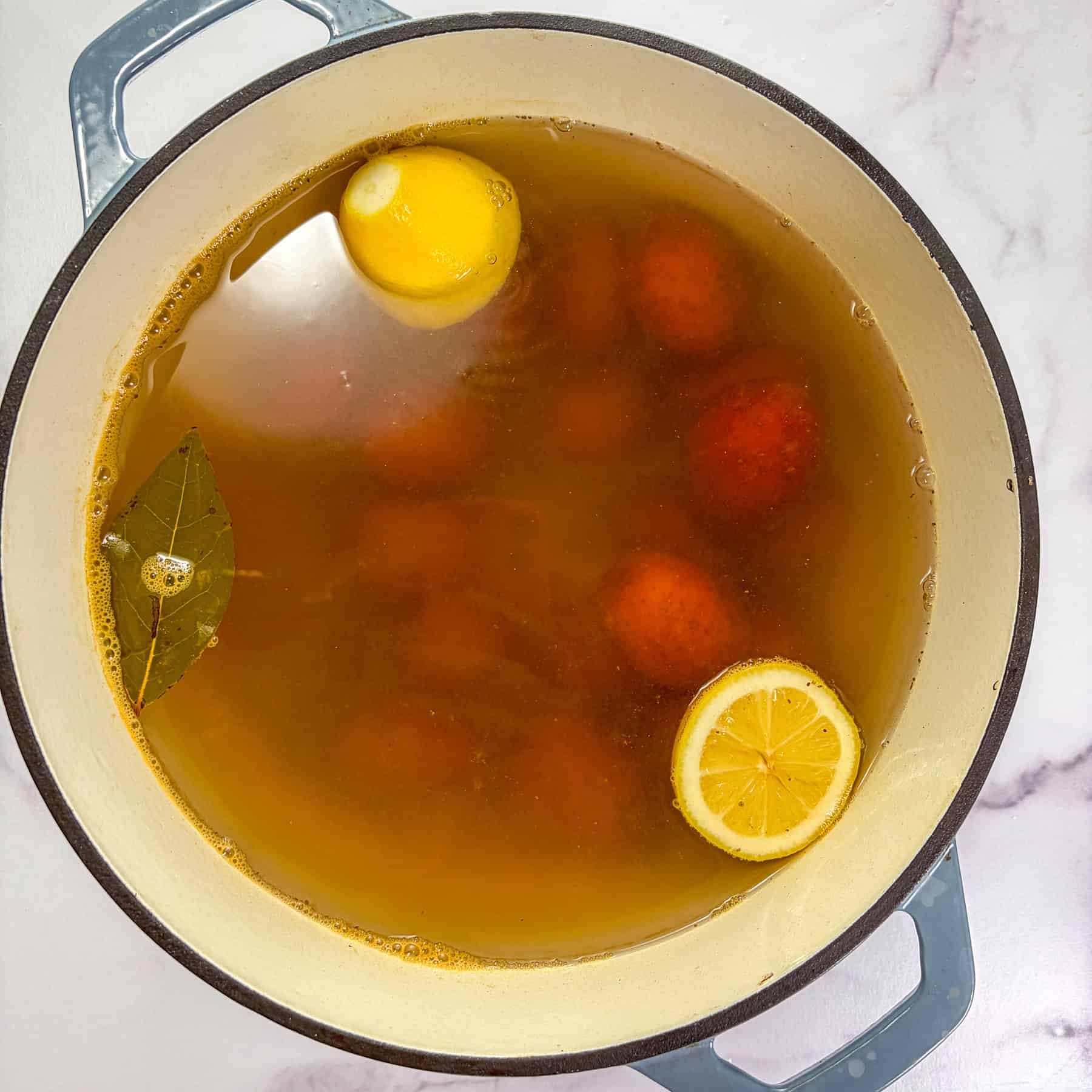 Potatoes boiling in a large pot of water.